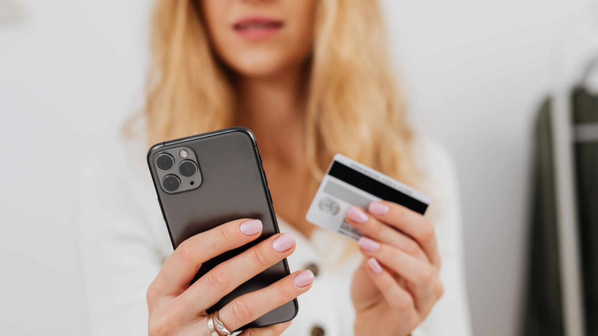 Customer using a smartphone and credit card to make a digital purchase.