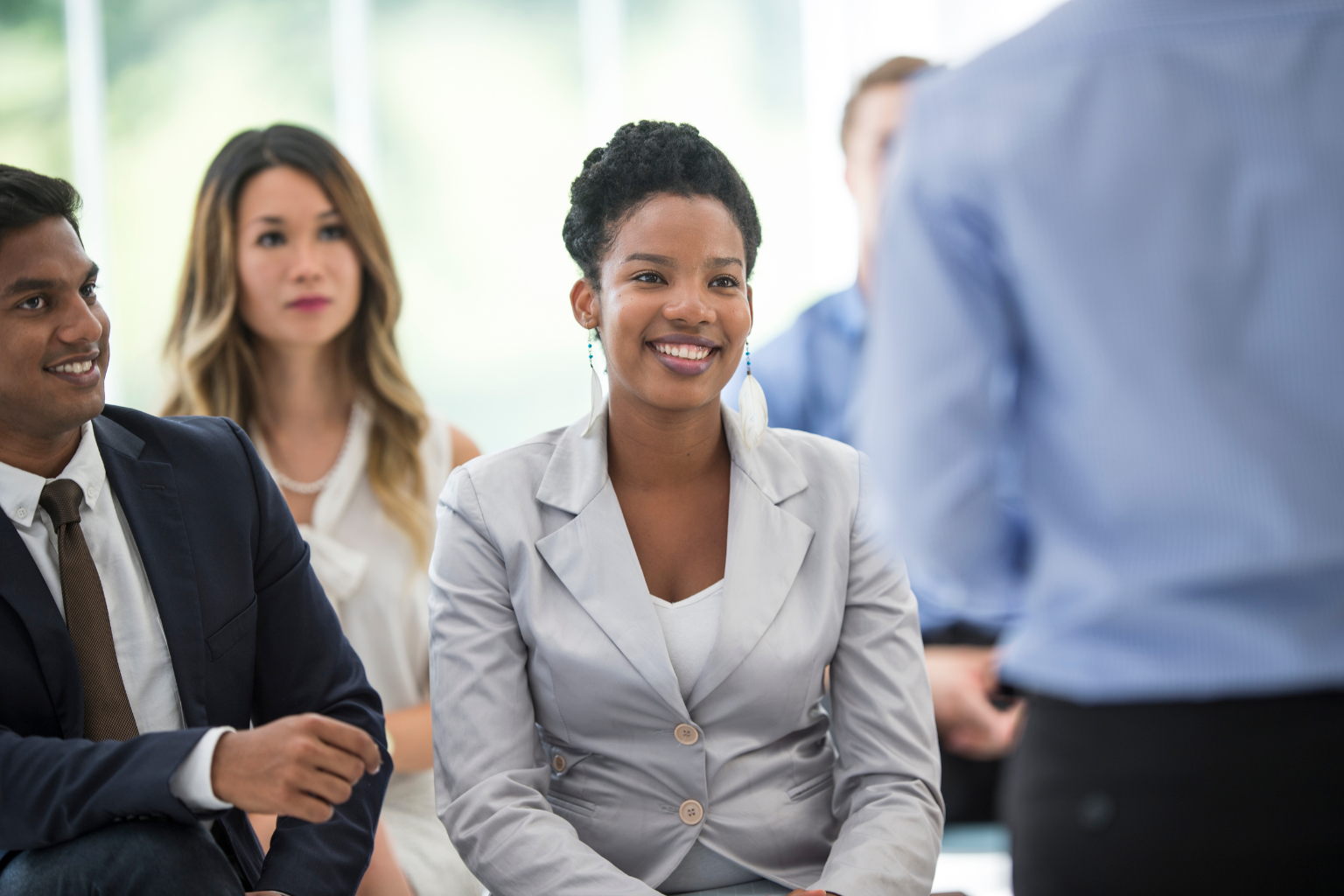 diverse group of professionals looking at the the presenter