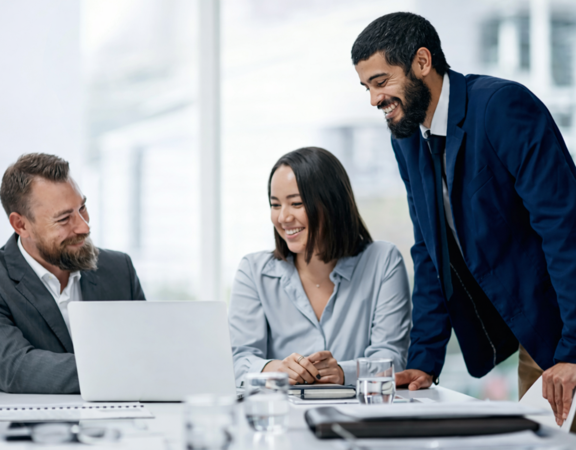 three professionals collaborating over a laptop