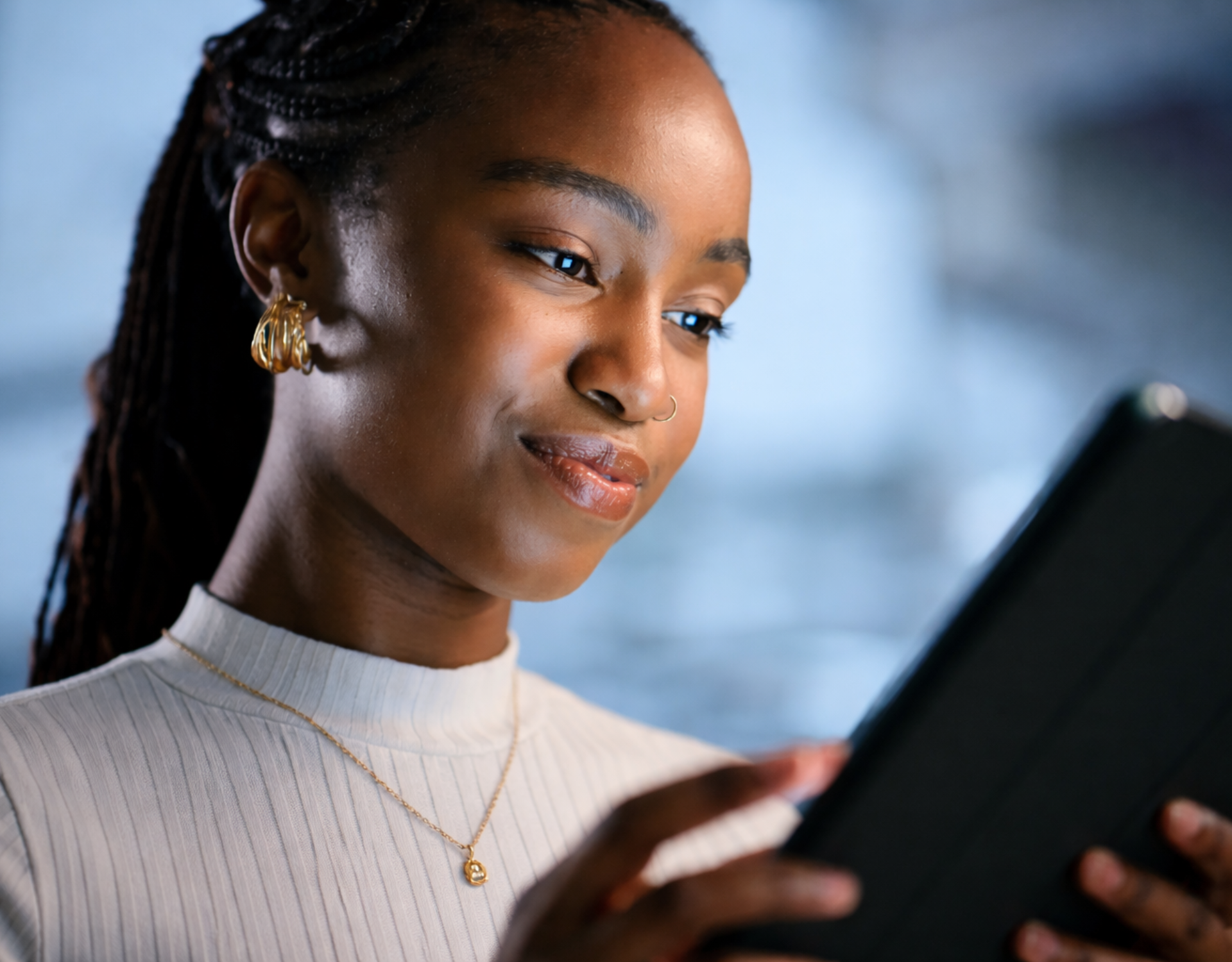 young black female smiling at her tablet screen