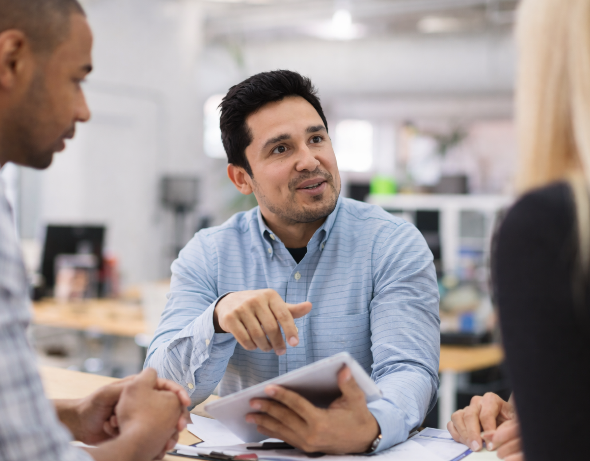 middle aged male analyzing paperwork with a group of colleagues