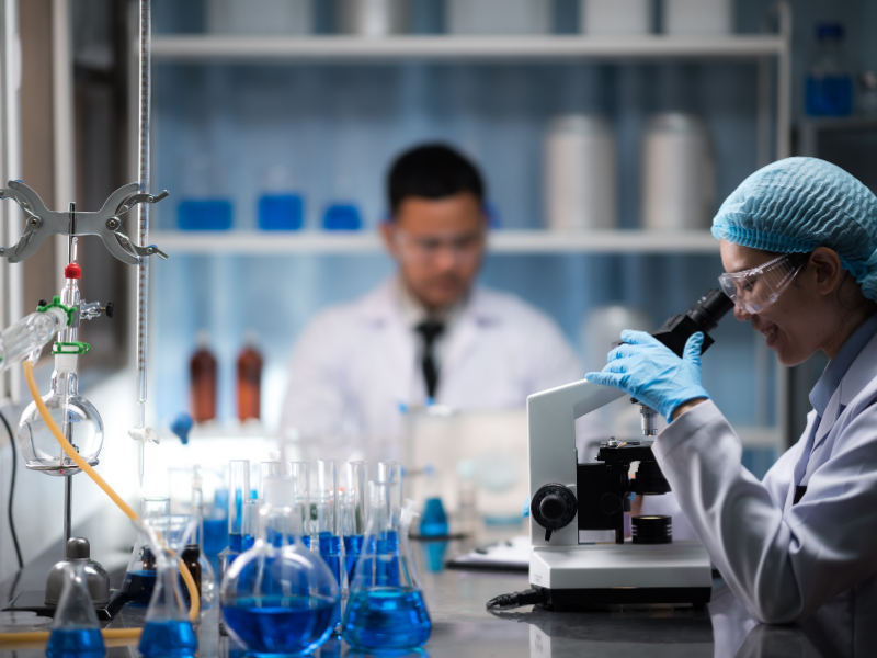 female scientist conducting research under the microscope