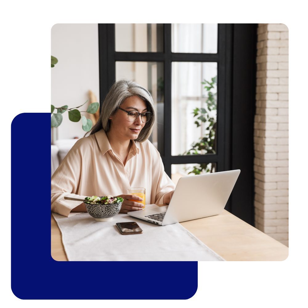 mature asian female in glasses working on a laptop