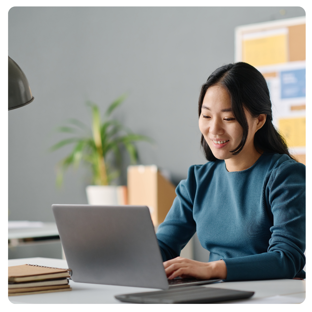 young asian female smiling at her laptop