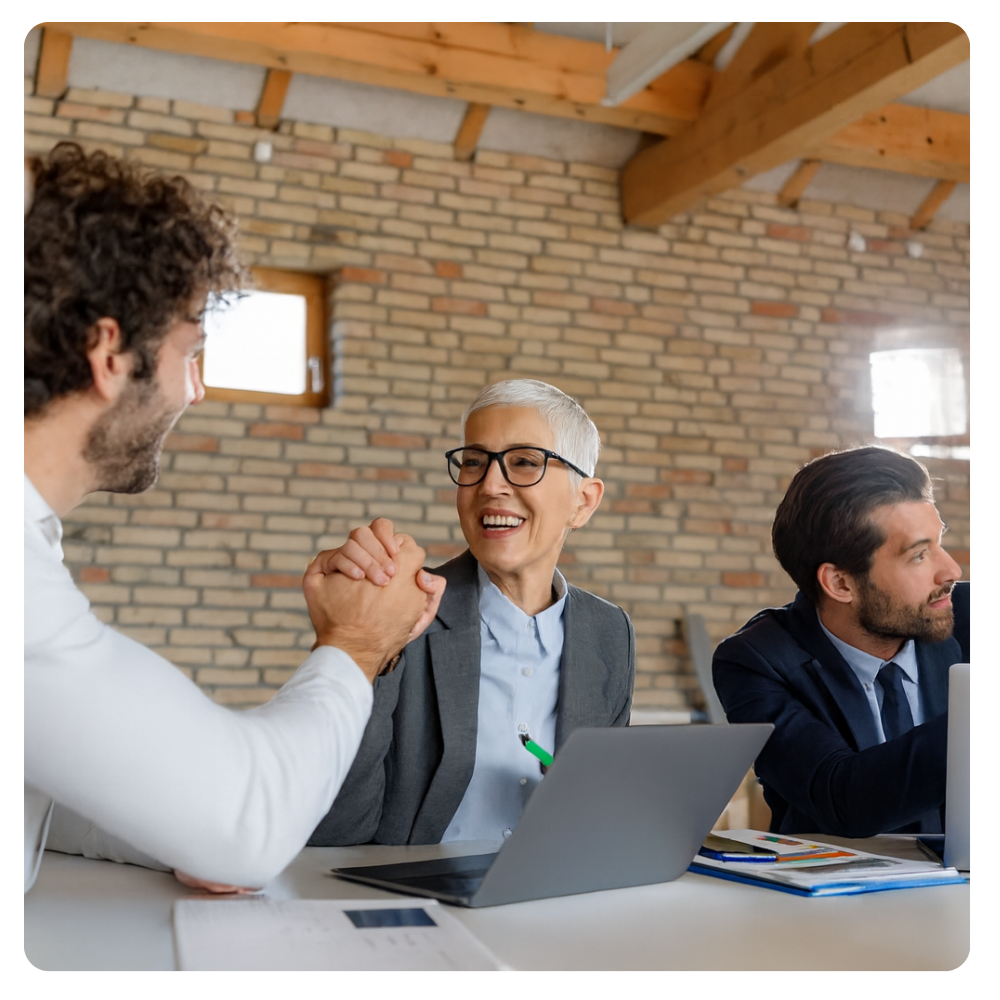 a man and woman exchanging a congratulatory handshake