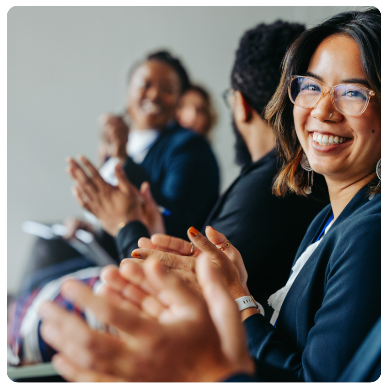 a group of young professionals clapping and laughing