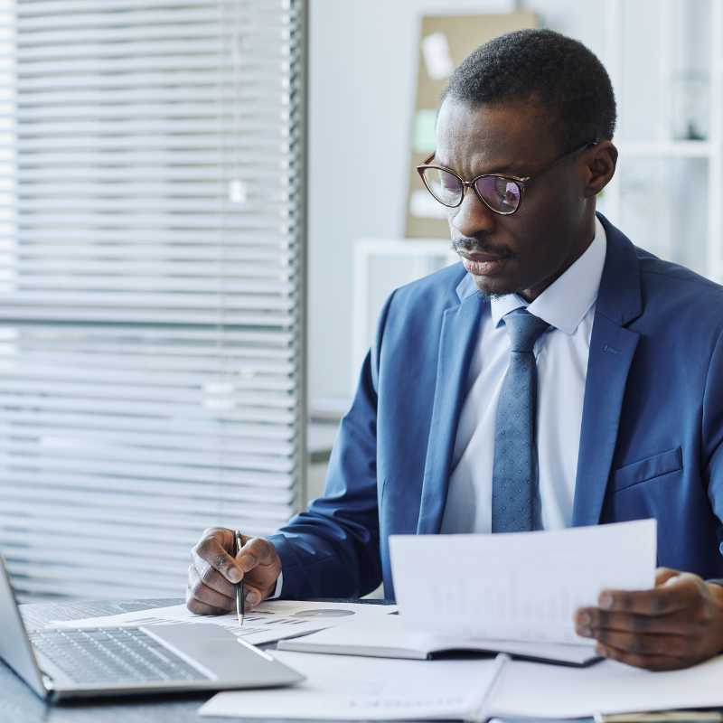 black male in glasses reviewing data