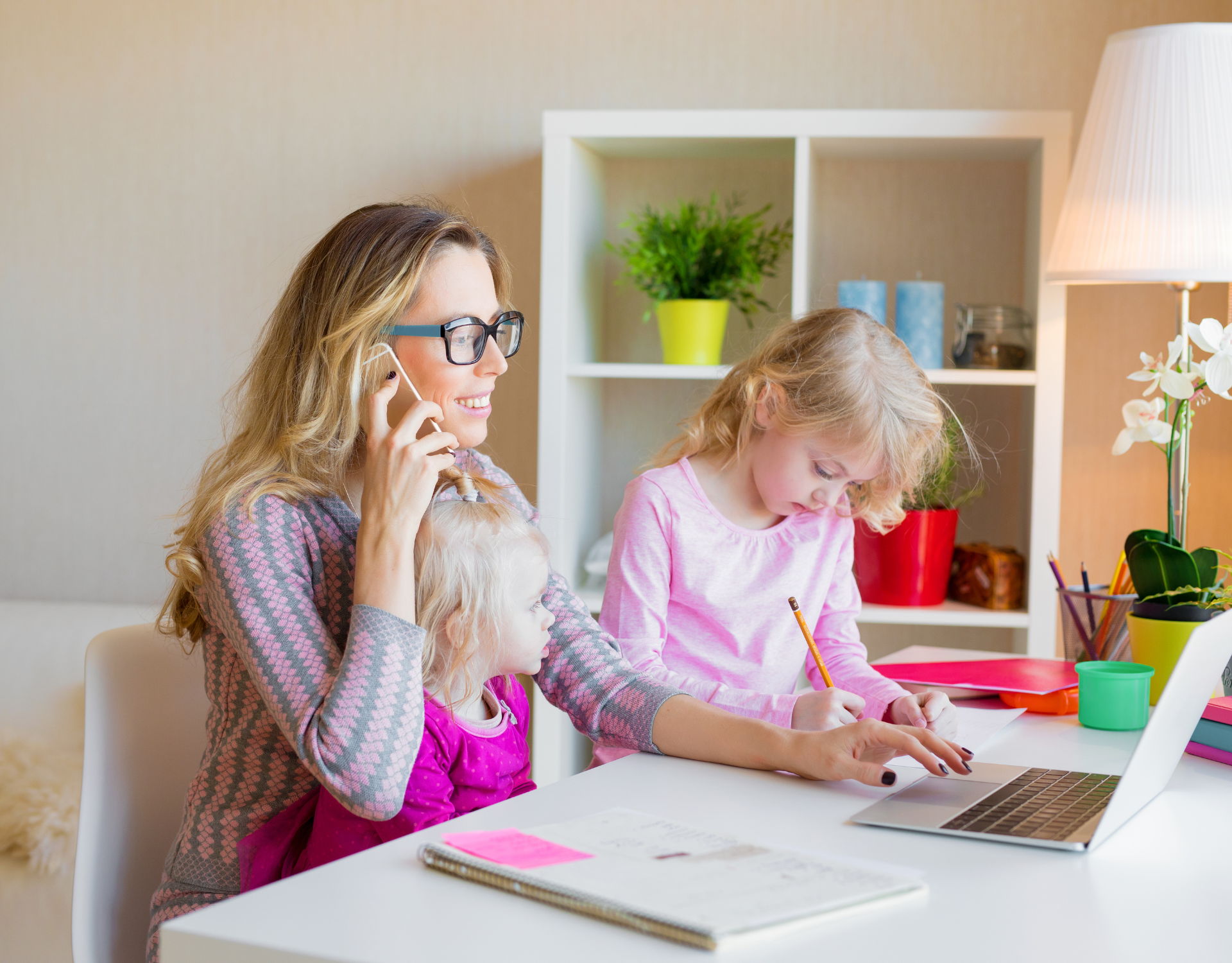 Parent working from home while caring for children representing employee wellbeing and work life balance.